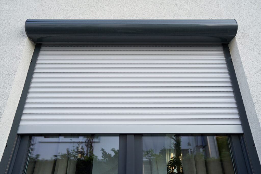 Geïsoleerde elektrische rolluiken in antraciet, gemonteerd op moderne raamprofielen voor optimale beveiliging en zonwering.